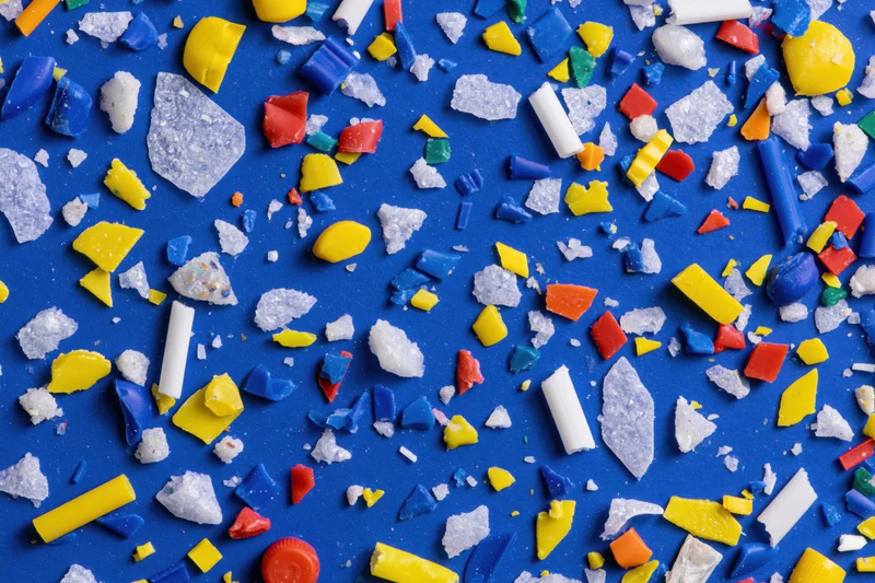 Scattered colorful plastic fragments on blue surface