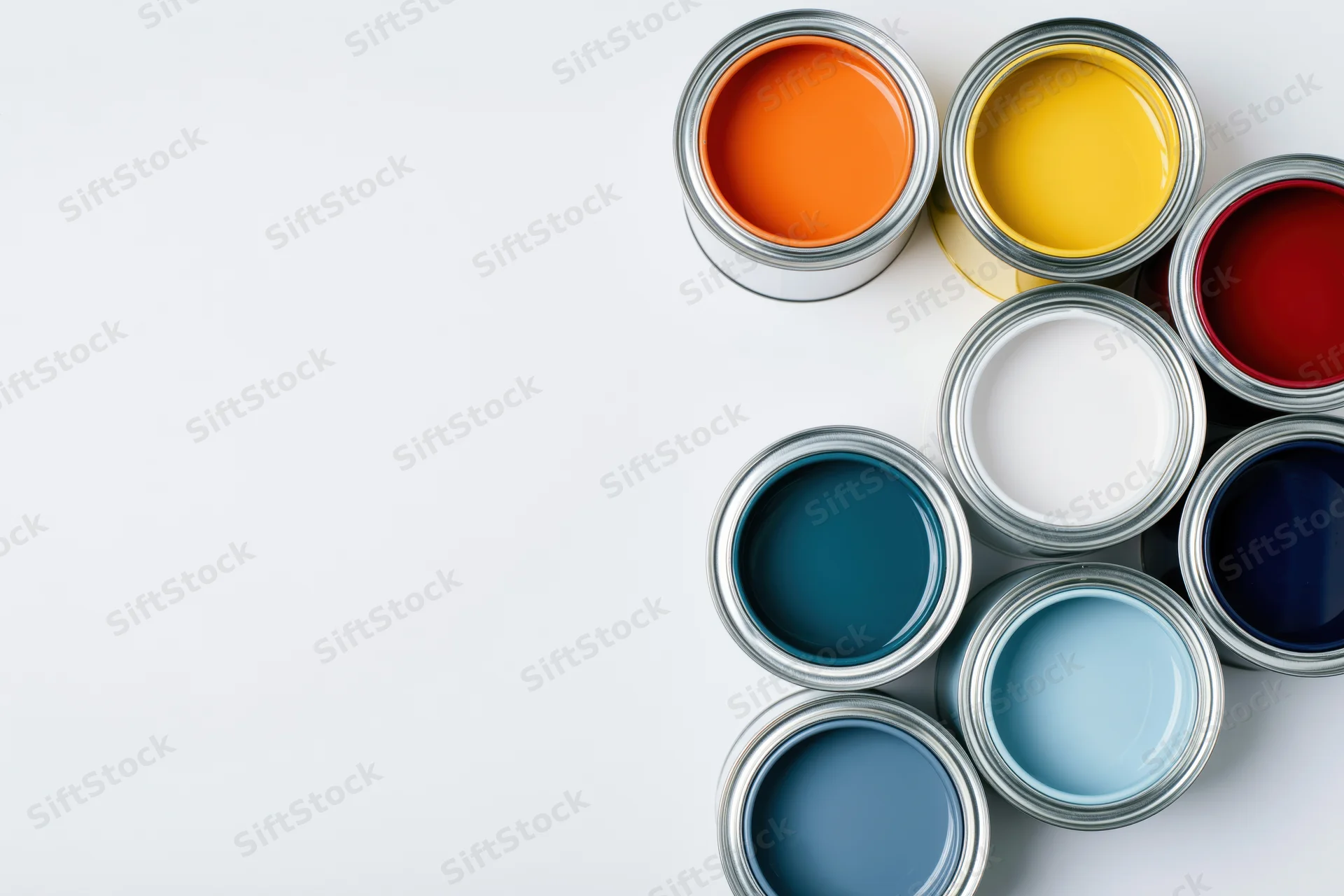 Open paint cans arranged in a diagonal cluster on a white surface with copyspace