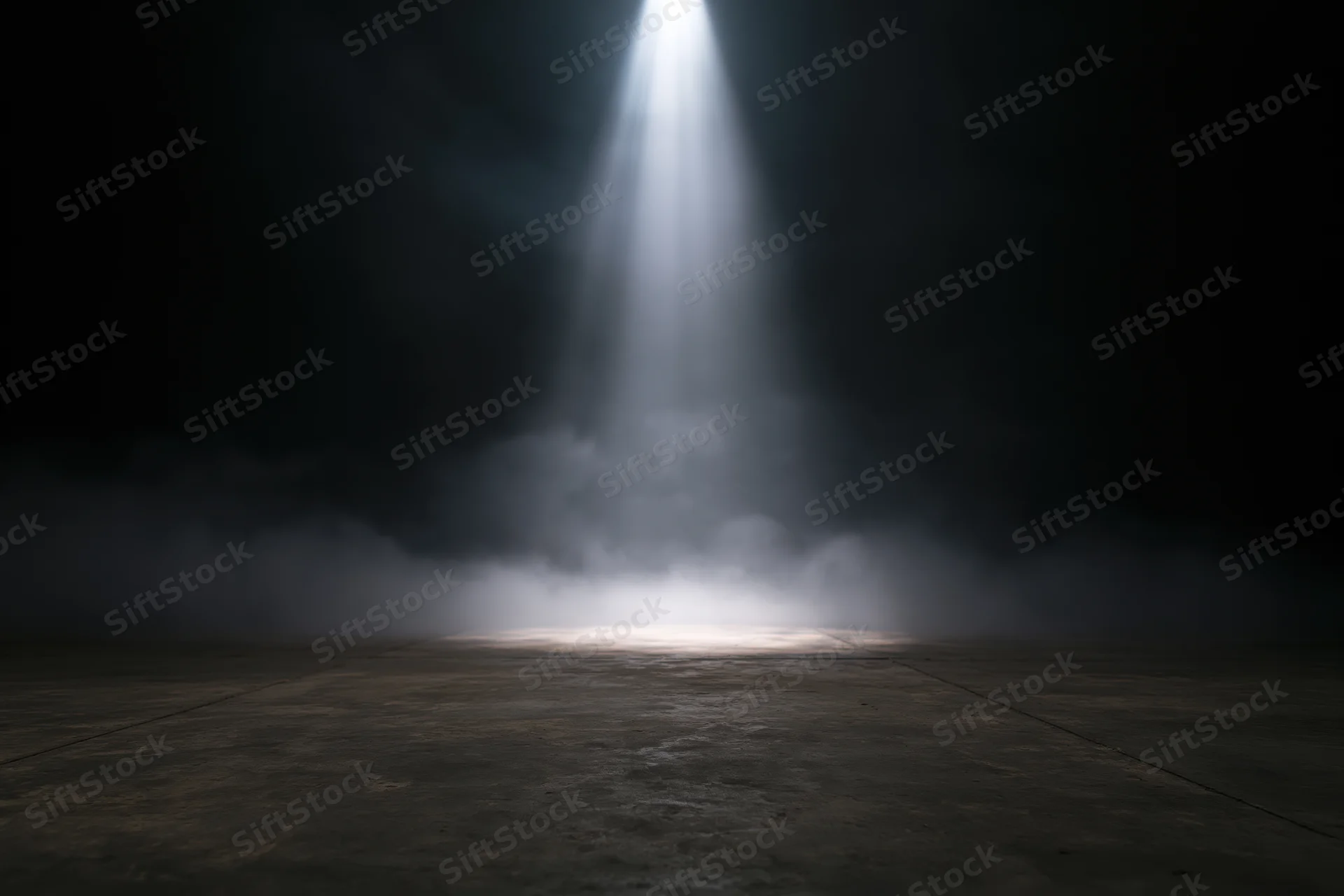 Single spotlight beam illuminating a smoky concrete floor in a dark theater space