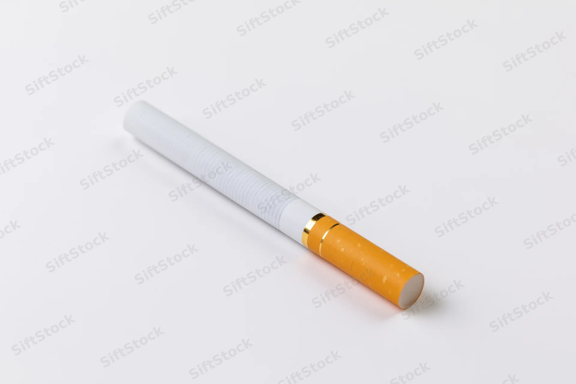 Unlit cigarette lying diagonally on a white surface