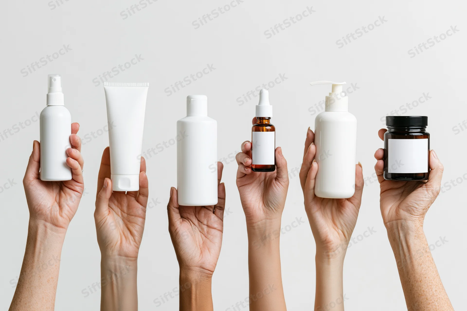Six female hands holding different skincare product containers against a white background