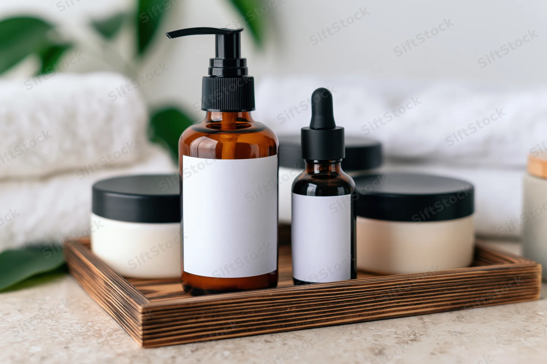 Skincare products arranged on a wooden tray with towels and greenery in a bathroom setting