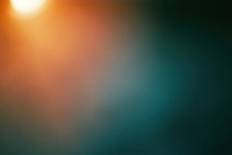 Soft out-of-focus abstract background with warm amber-orange glow transitioning to dark teal