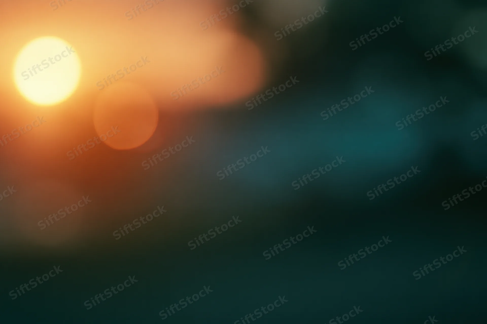 Soft out-of-focus abstract background with warm amber-orange glow and dark teal gradient