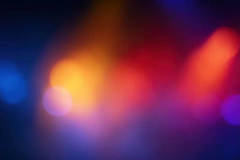 Soft out-of-focus bokeh lights blending in warm and cool tones across a dark background