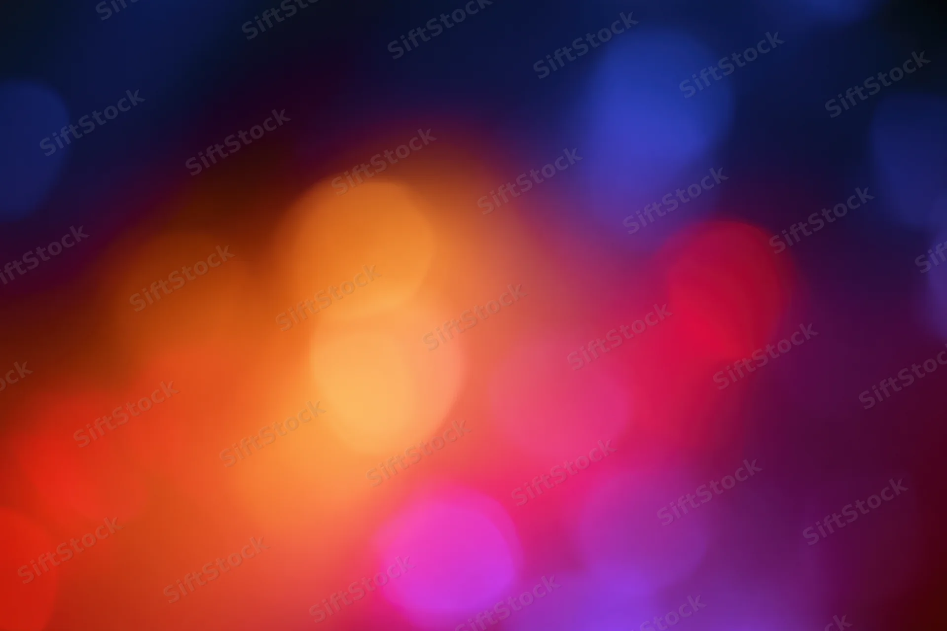 Soft out-of-focus bokeh background with warm and cool colored lights blending in abstract pattern
