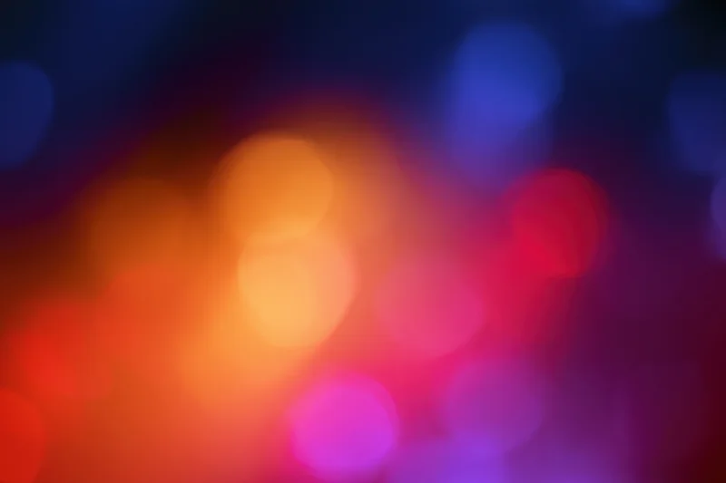 Soft out-of-focus bokeh background with warm and cool colored lights blending in abstract pattern
