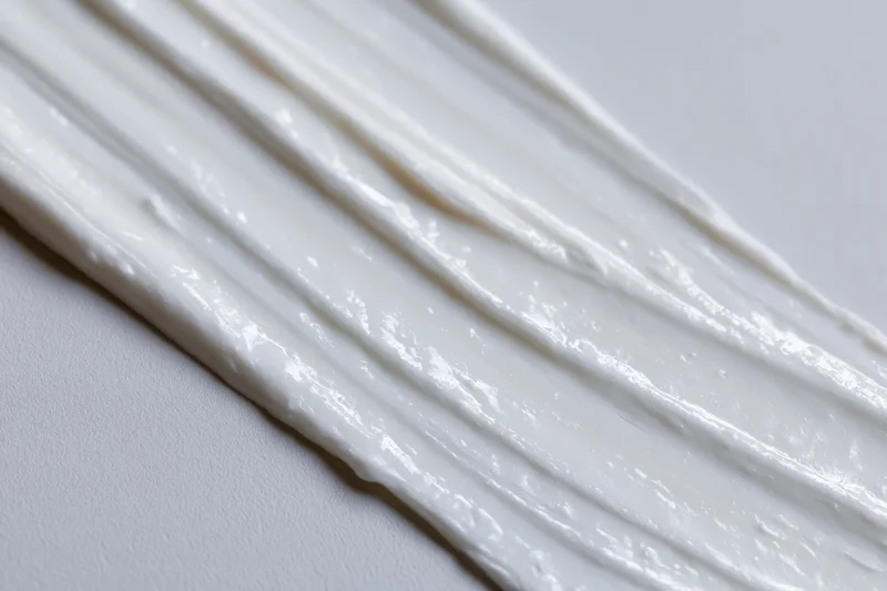 Diagonal swipes of white cream smeared across a plain surface