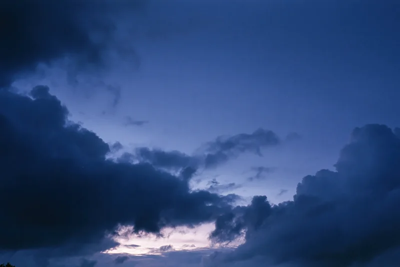 Twilight sky with scattered dark storm clouds at dusk