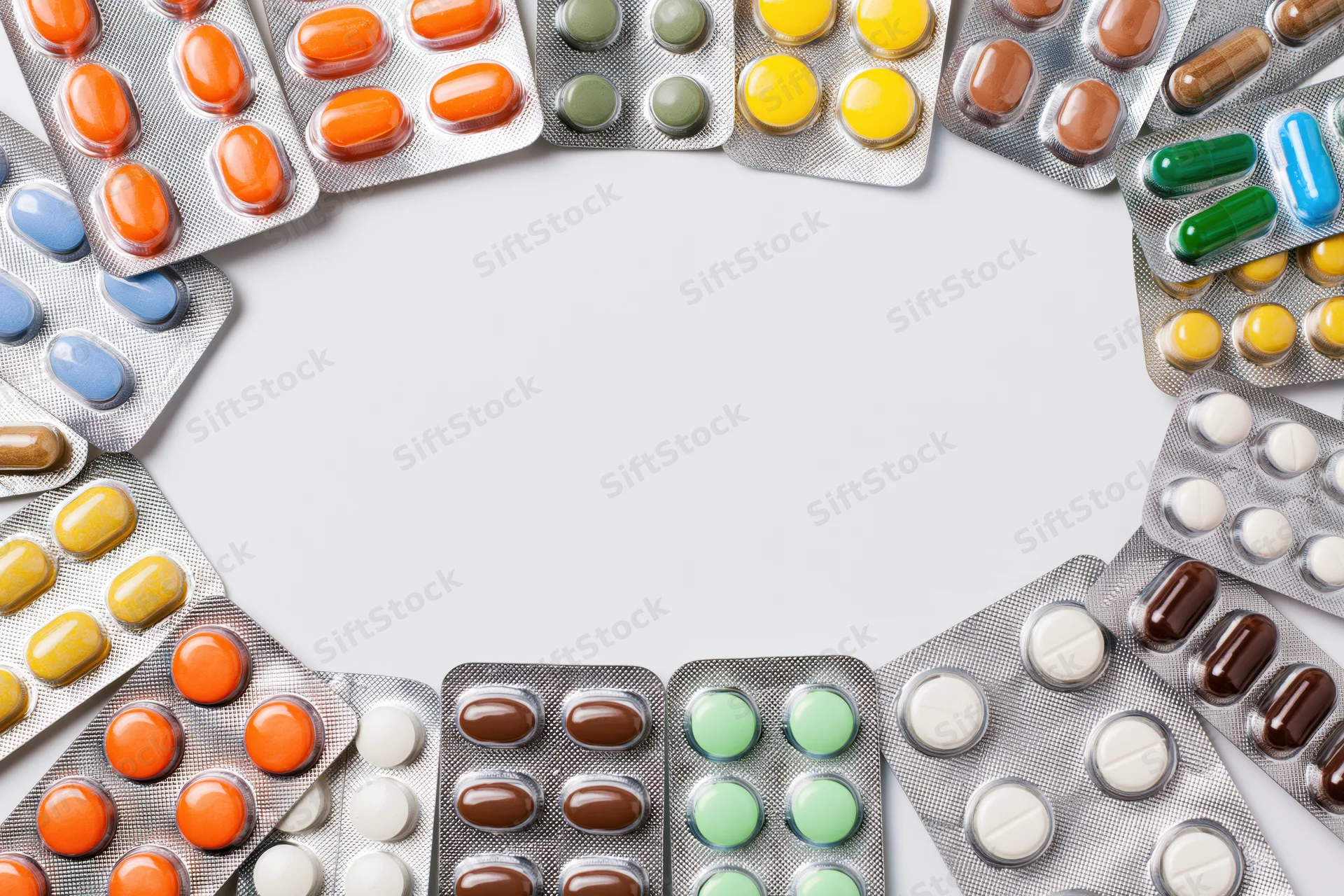 Various pharmaceutical blister packs arranged in a border frame on white background with copyspace