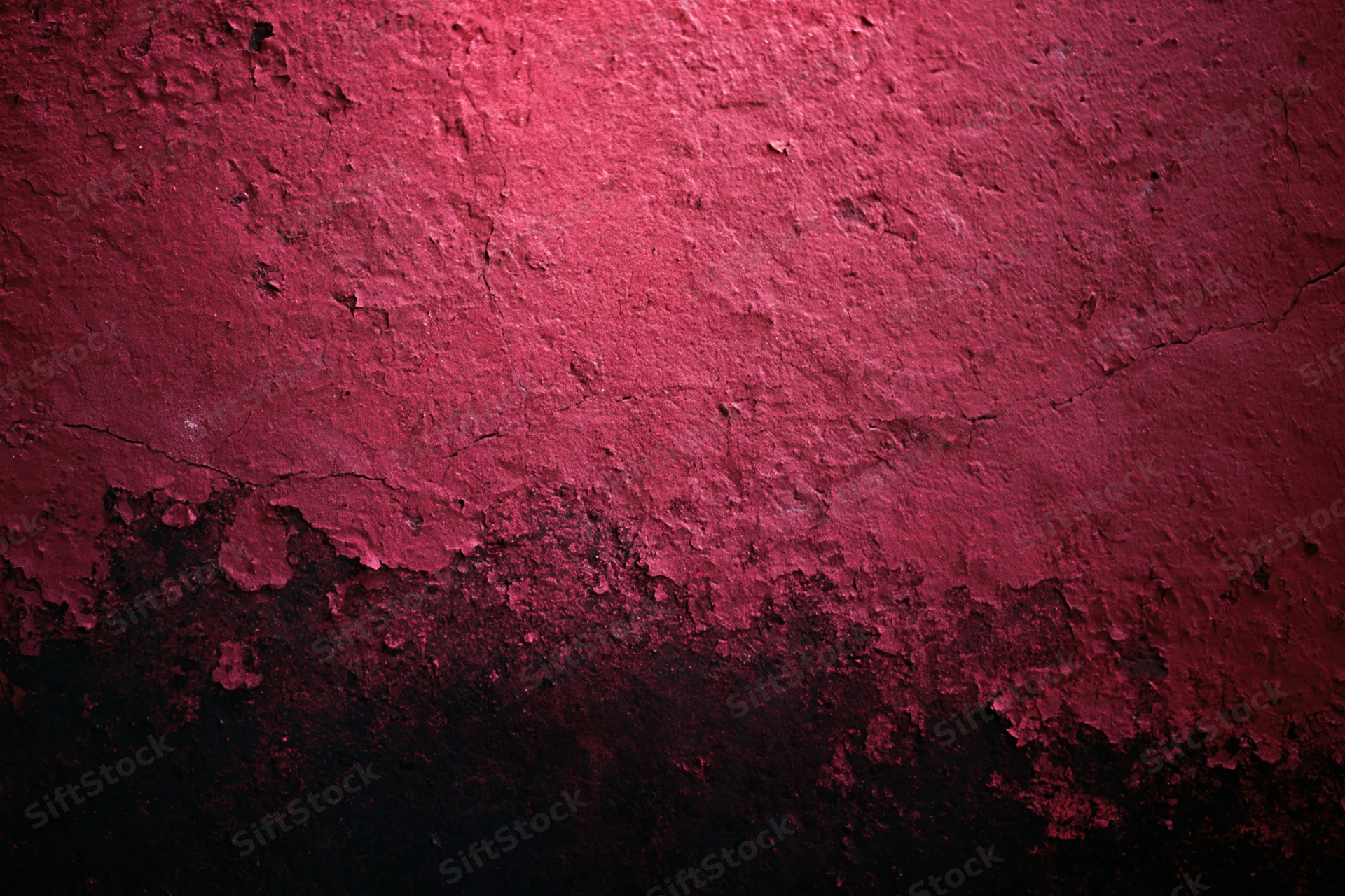 Weathered red concrete wall with peeling paint and cracks