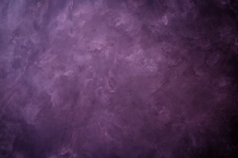 Weathered purple plaster wall surface filling the frame