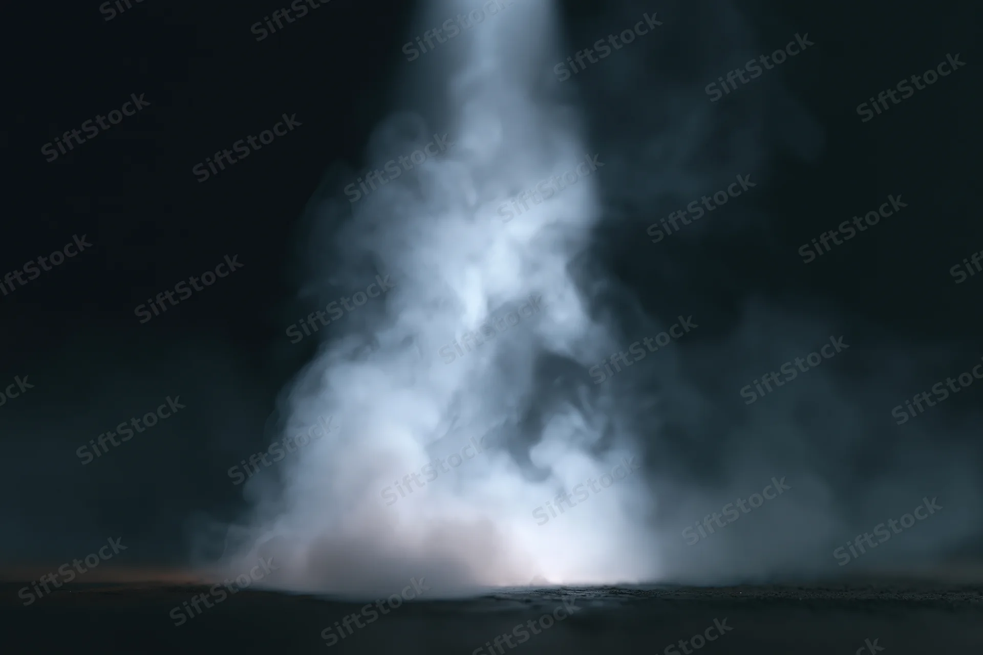 White smoke rising from a dark surface in a studio setting