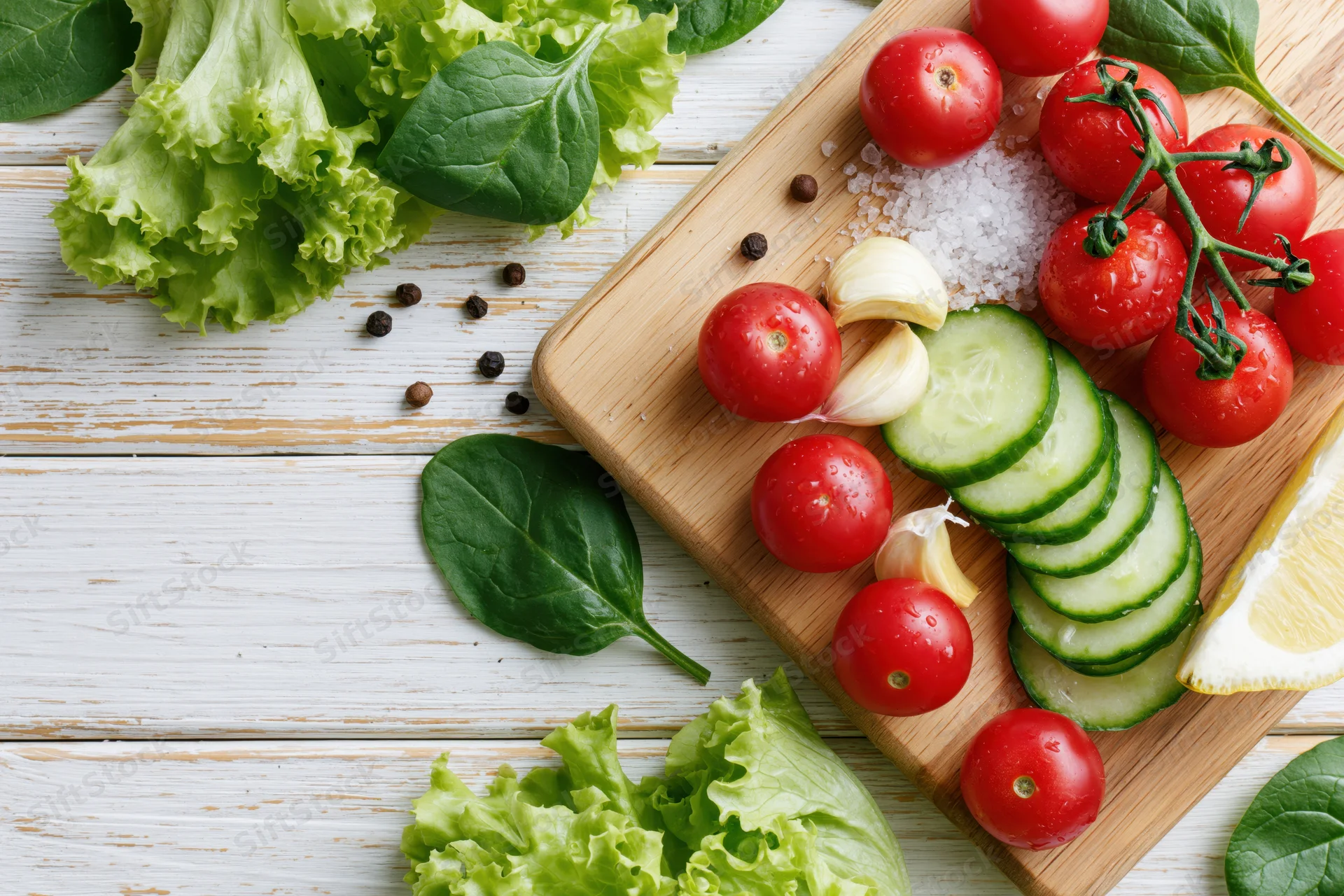 Fresh vegetables arranged on a wooden cutting board with herbs and spices for salad preparation