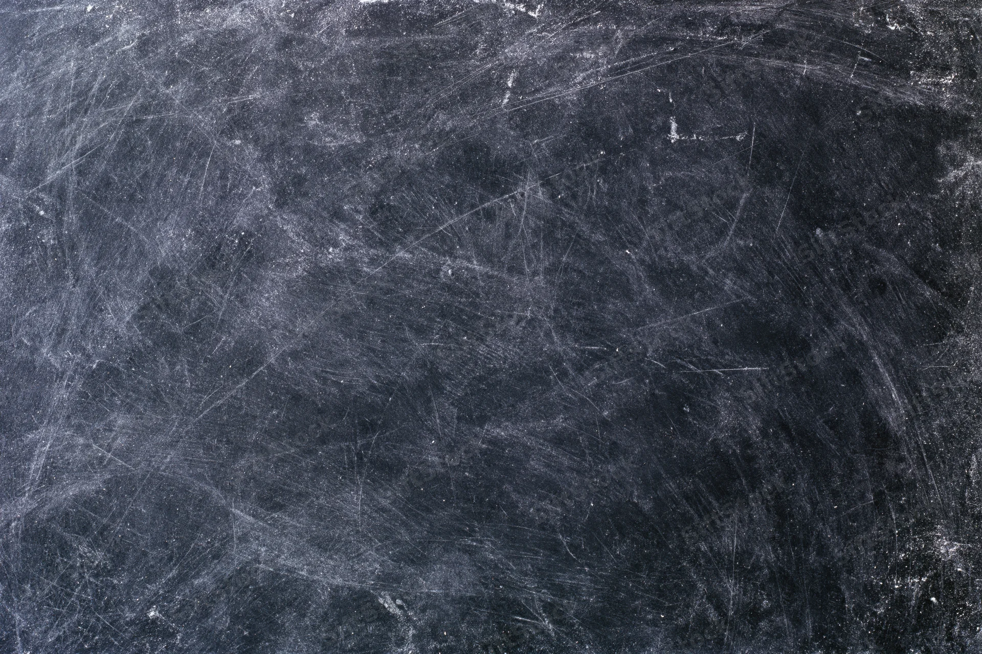 Worn black chalkboard surface covered in chalk dust and fine scratches