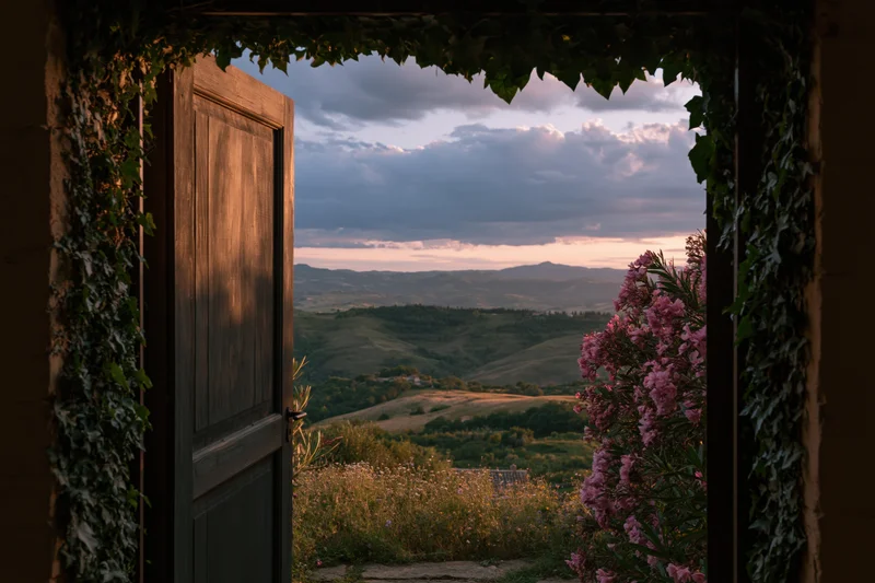 Open wooden door framing a sweeping countryside view at sunset