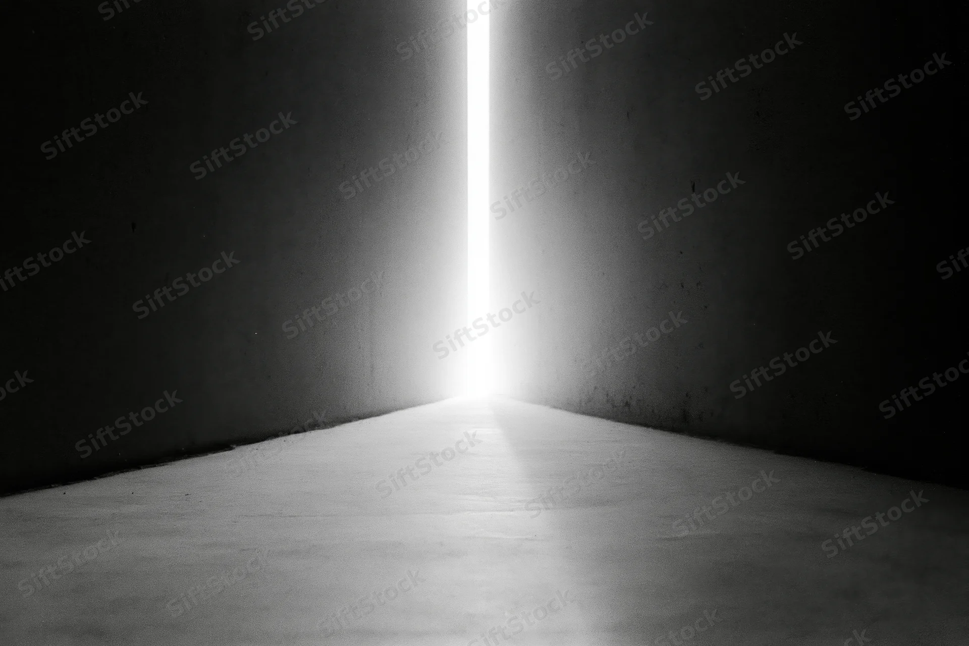 Bright vertical light beam in narrow gap between dark concrete walls in a corridor