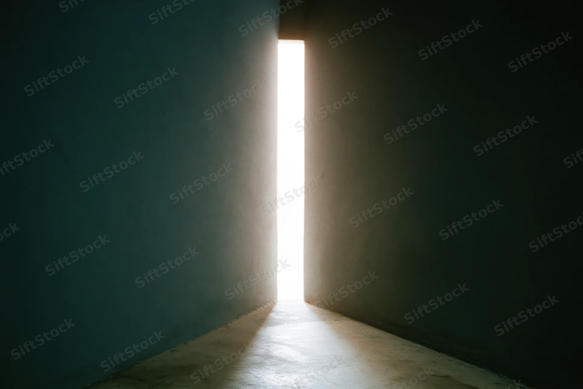 Narrow vertical gap between dark concrete walls letting in bright light