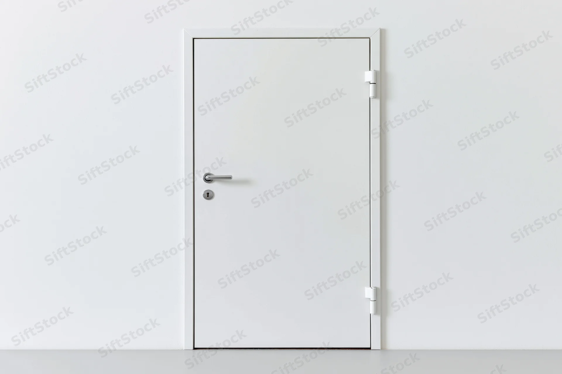 White steel door with lever handle and keyhole in a minimalist interior