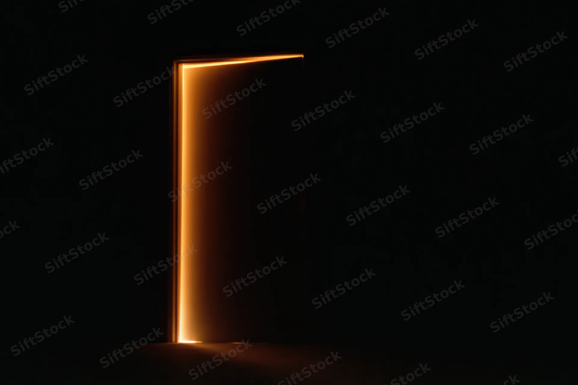 Slightly ajar interior door glowing with warm light in dark space