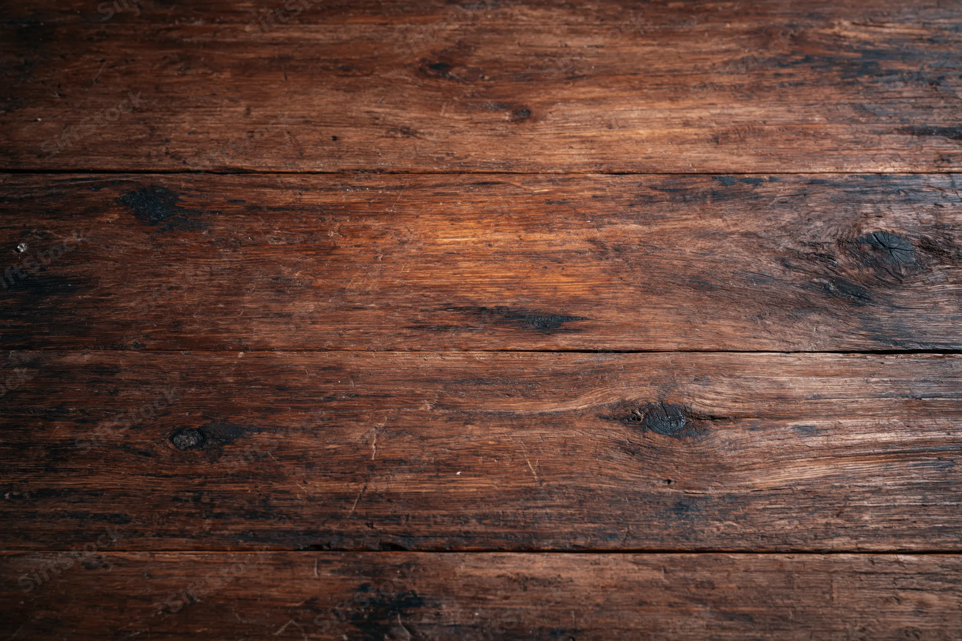 Dark aged wooden surface with horizontal planks and visible grain filling the frame