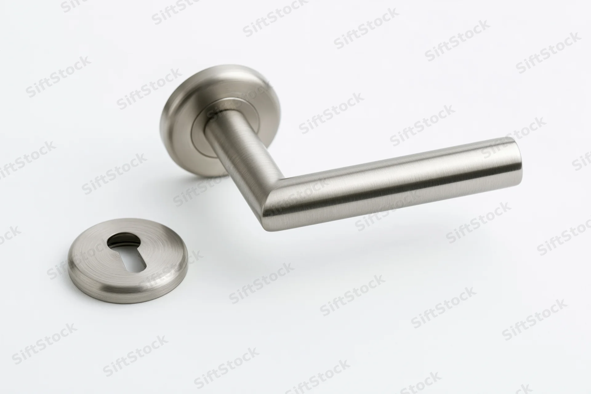 Brushed stainless steel door lever handle and round keyhole escutcheon on white background