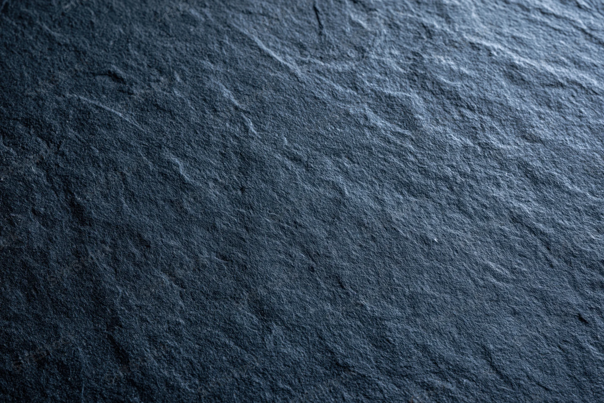 Close-up of dark slate stone surface with natural texture and grain