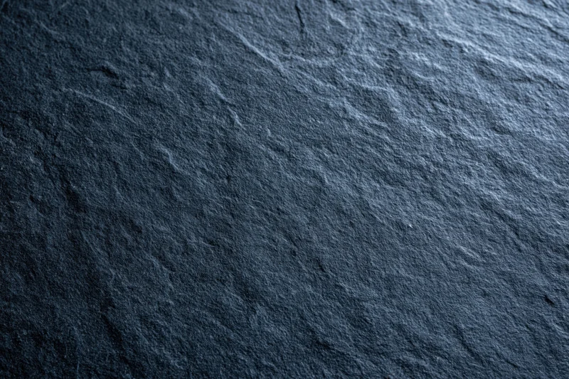 Close-up of dark slate stone surface with natural texture and grain
