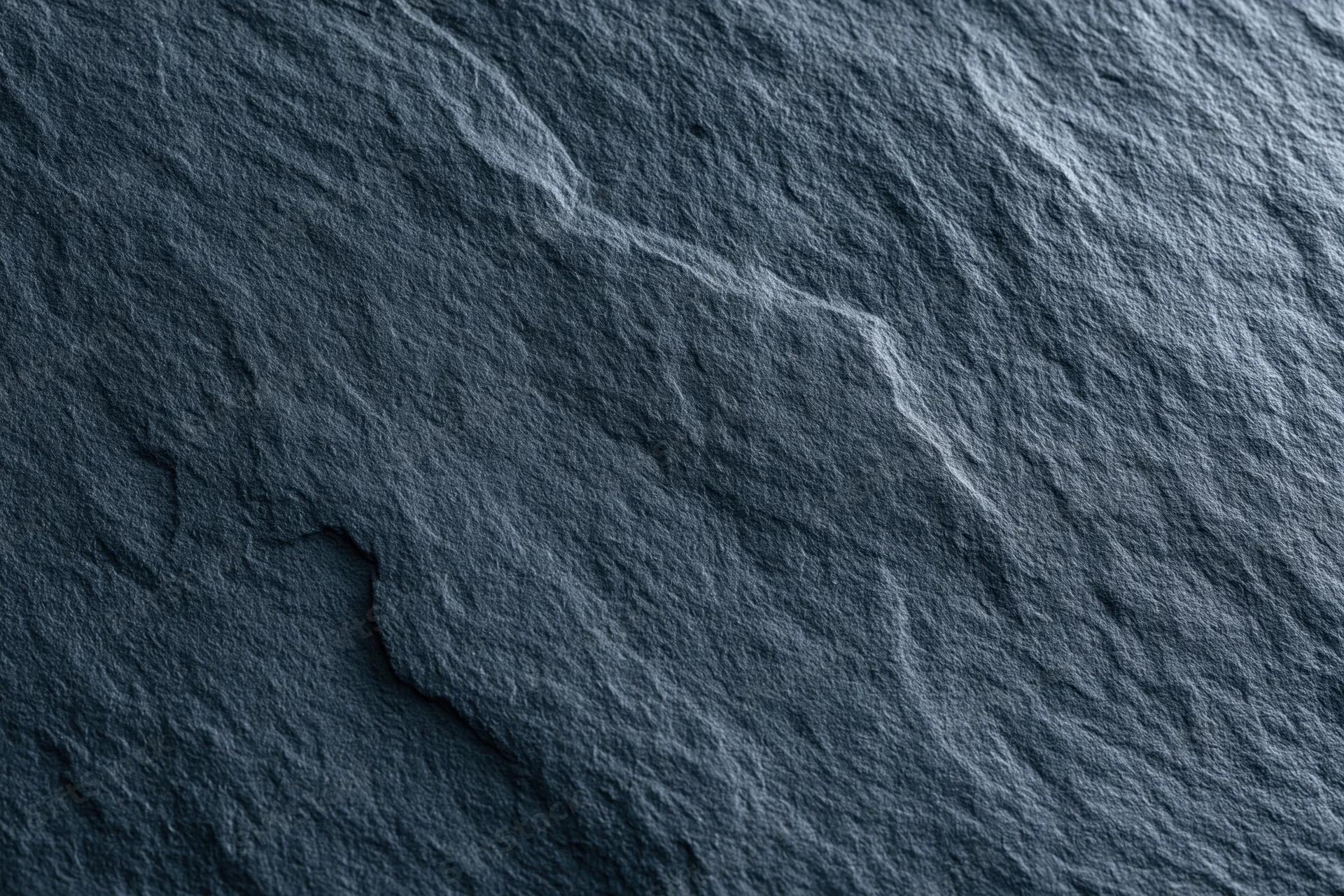 Close-up of dark slate stone surface with natural texture and grain