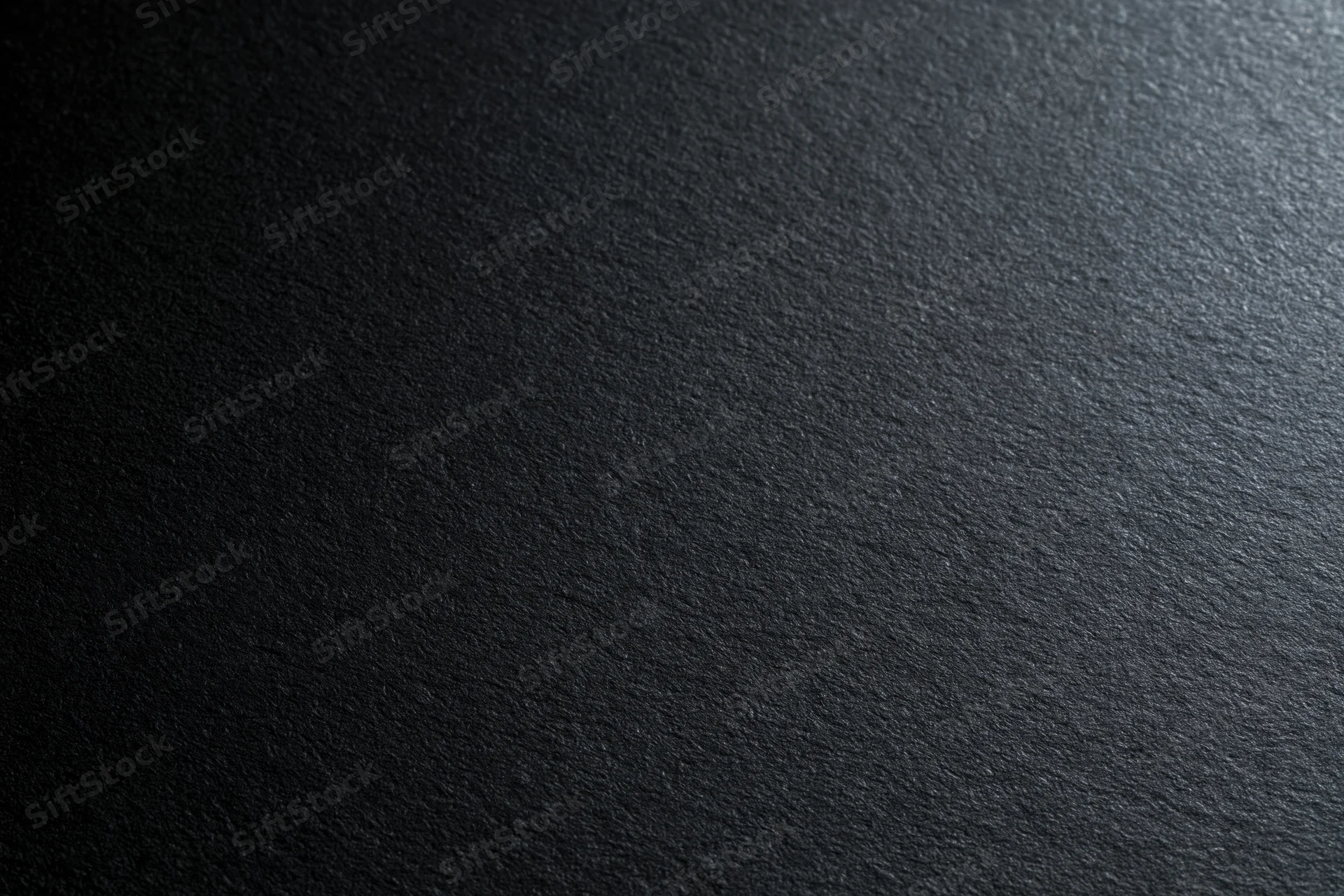 Close-up of black matte cardstock paper surface with fine texture and subtle grain, flat lay view