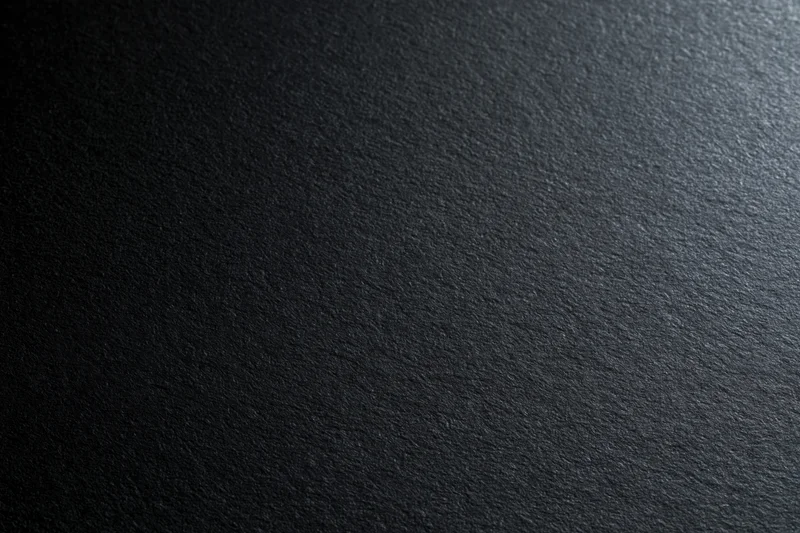 Close-up of black matte cardstock paper surface with fine texture and subtle grain, flat lay view