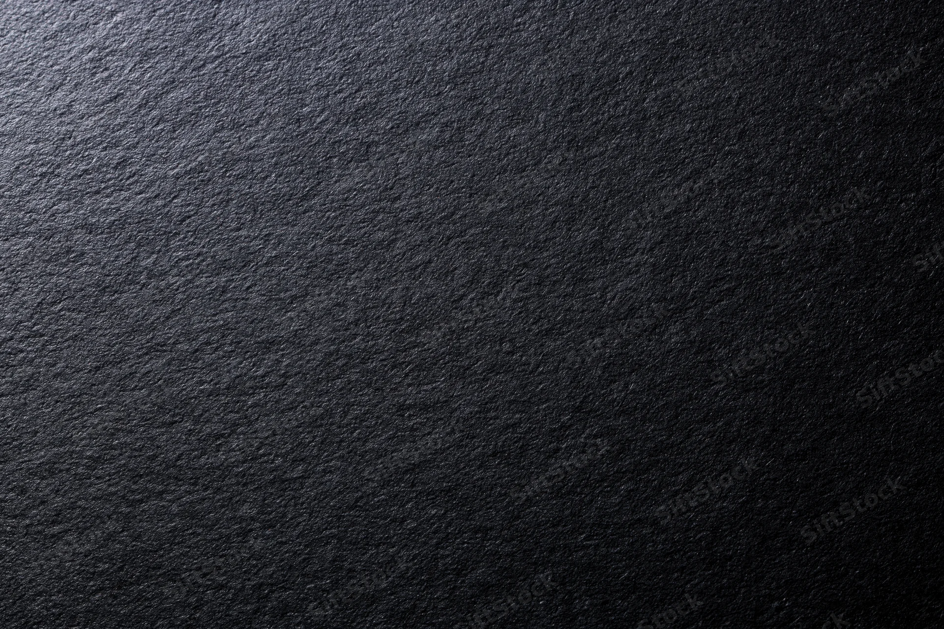 Close-up of black matte cardstock paper surface with textured grain filling the frame