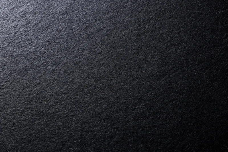 Close-up of black matte cardstock paper surface with textured grain filling the frame