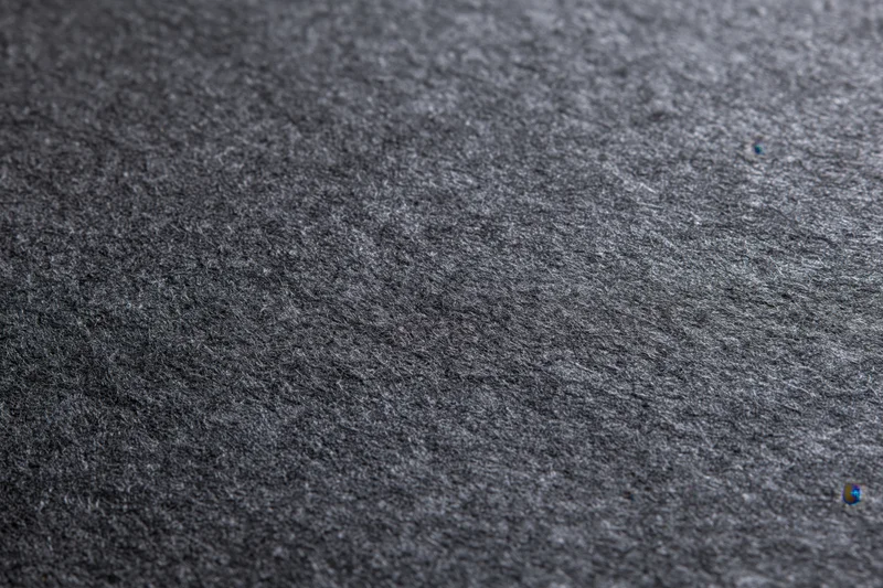 Close-up of dark charcoal grey textured paper surface