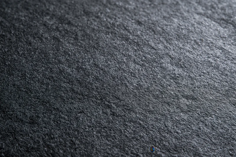 Close-up of dark charcoal grey textured paper surface in flat lay arrangement