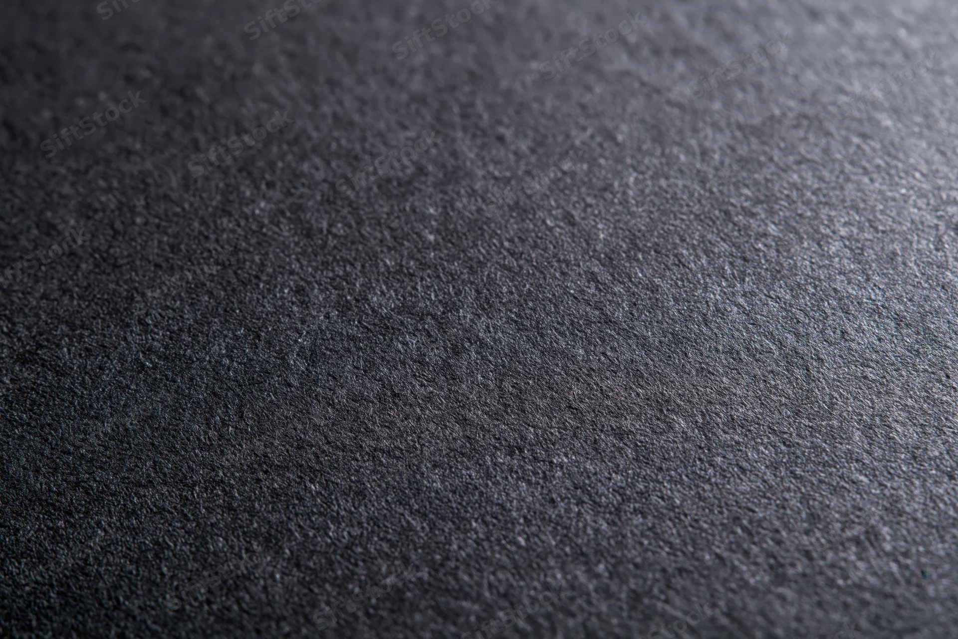 Close-up of dark charcoal grey textured paper surface in flat lay arrangement