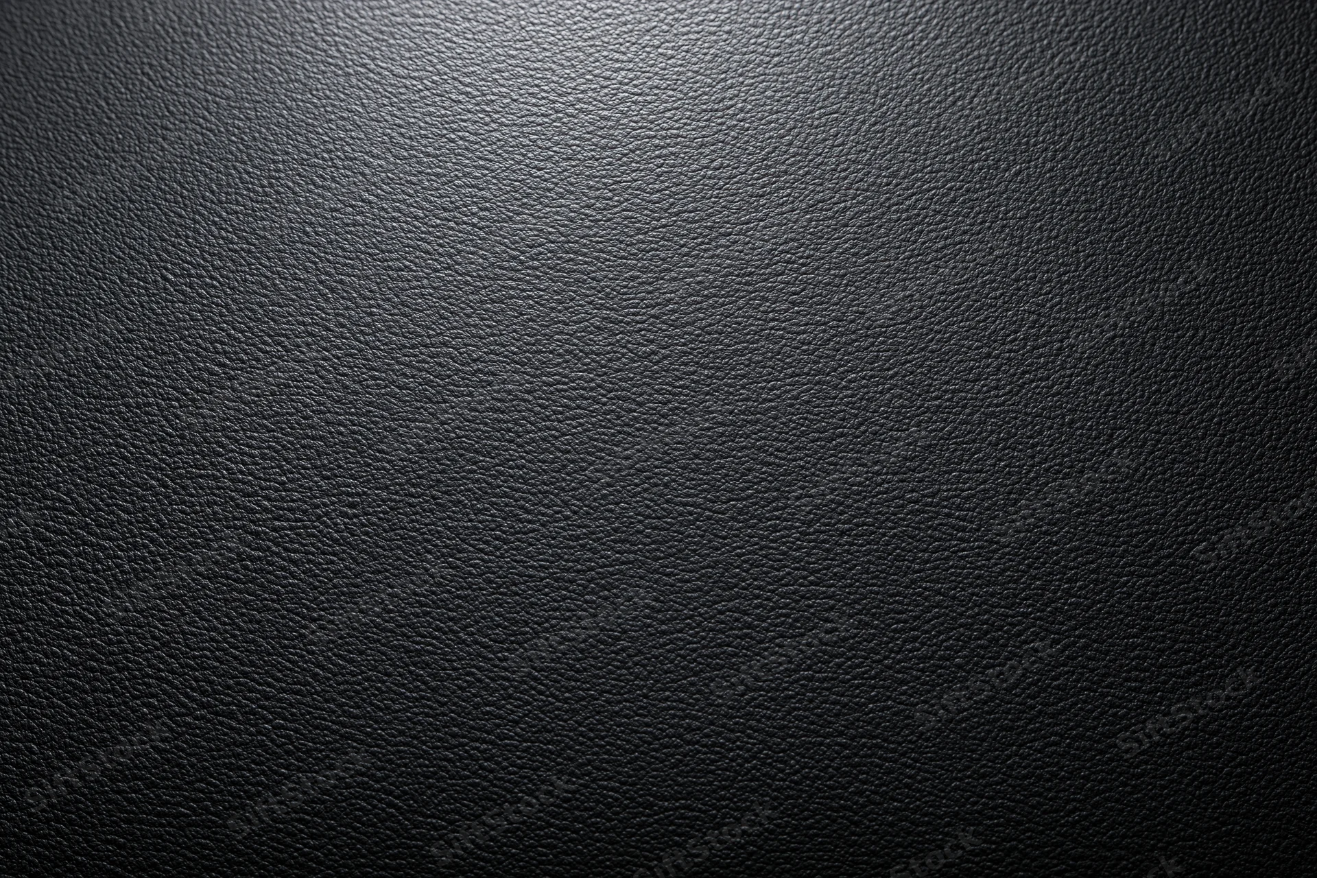 Close-up of dark charcoal leather surface with visible grain and texture