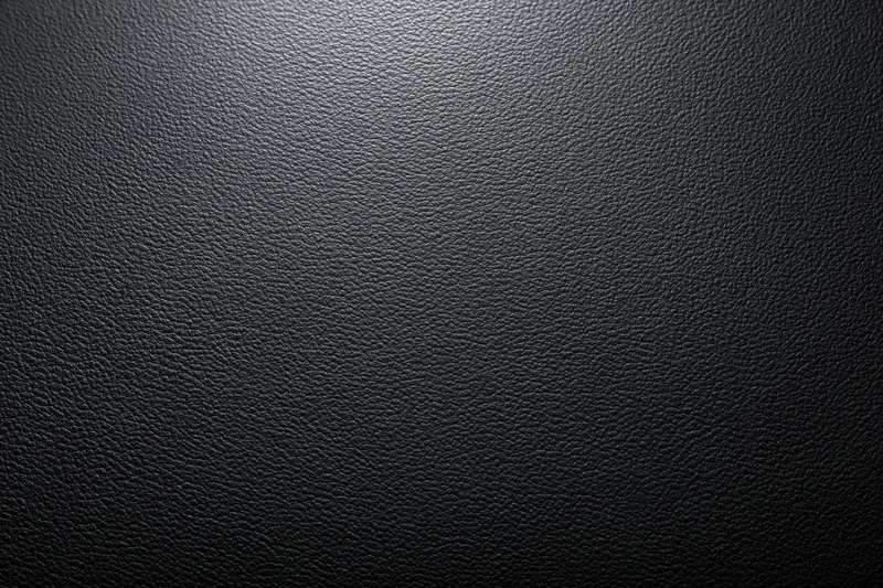 Close-up of dark charcoal leather surface with visible grain and texture
