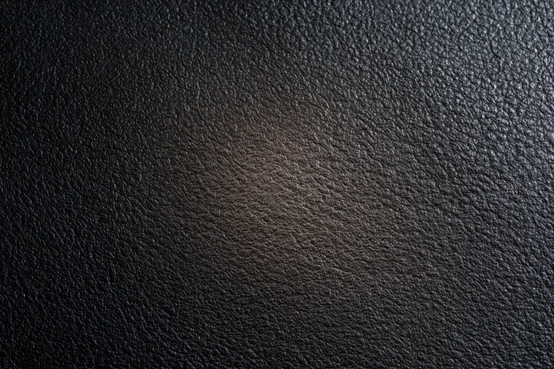 Close-up of dark charcoal leather surface with visible grain texture