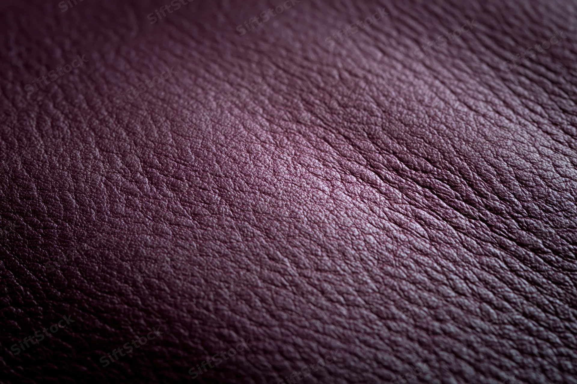 Close-up of deep purple leather surface showing natural grain and texture