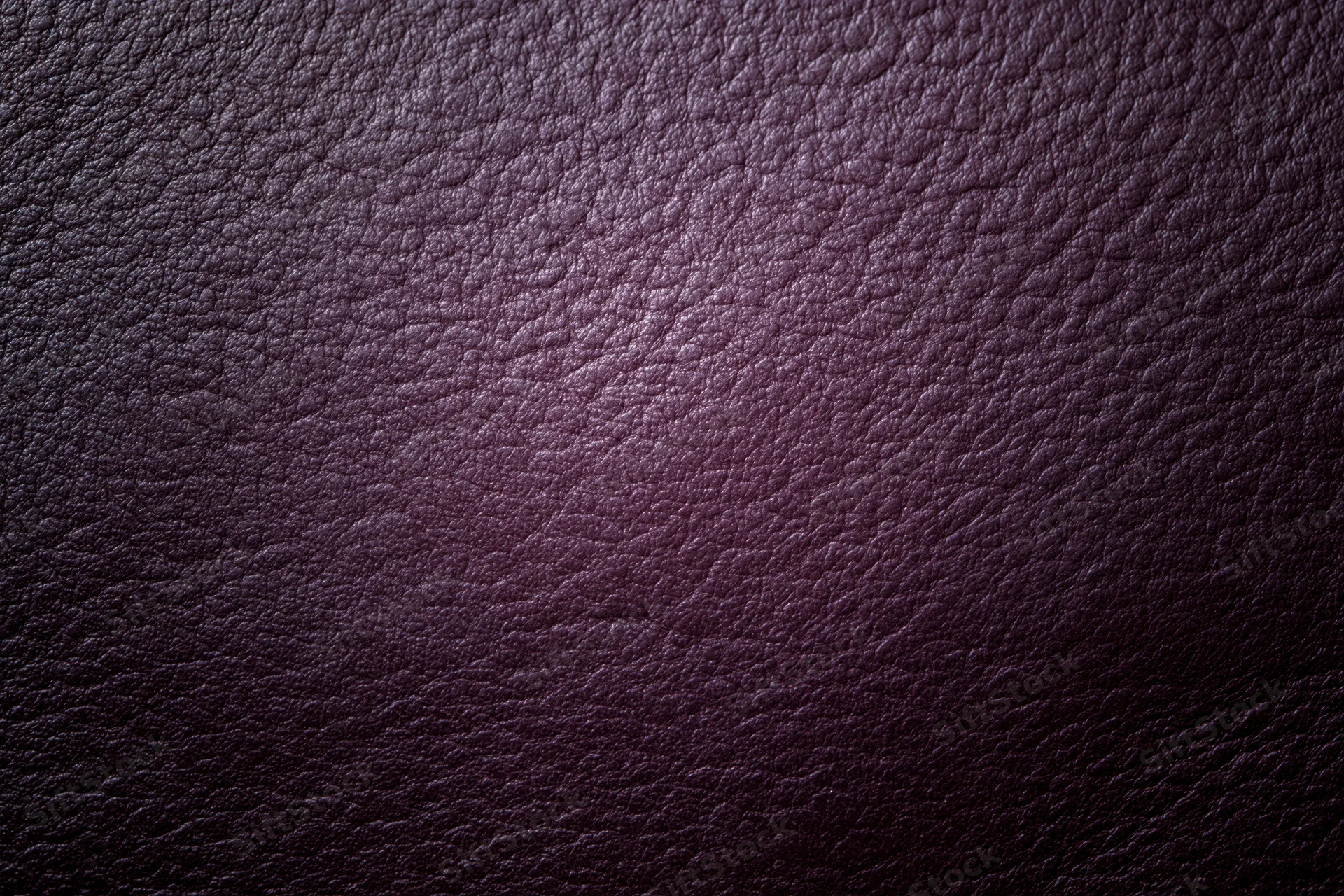Close-up of deep purple leather surface with visible grain texture
