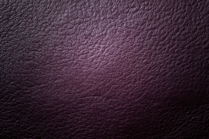 Close-up of deep purple leather surface with visible grain texture
