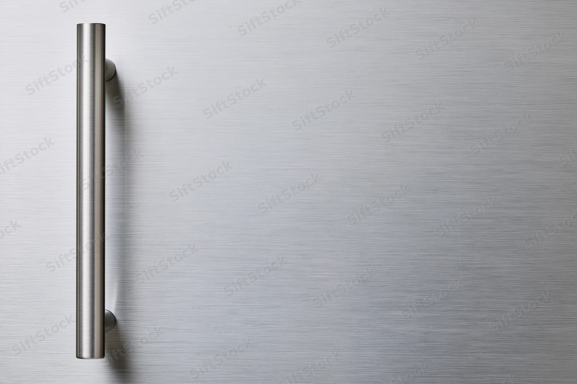 Brushed stainless steel refrigerator door with vertical handle on smooth surface