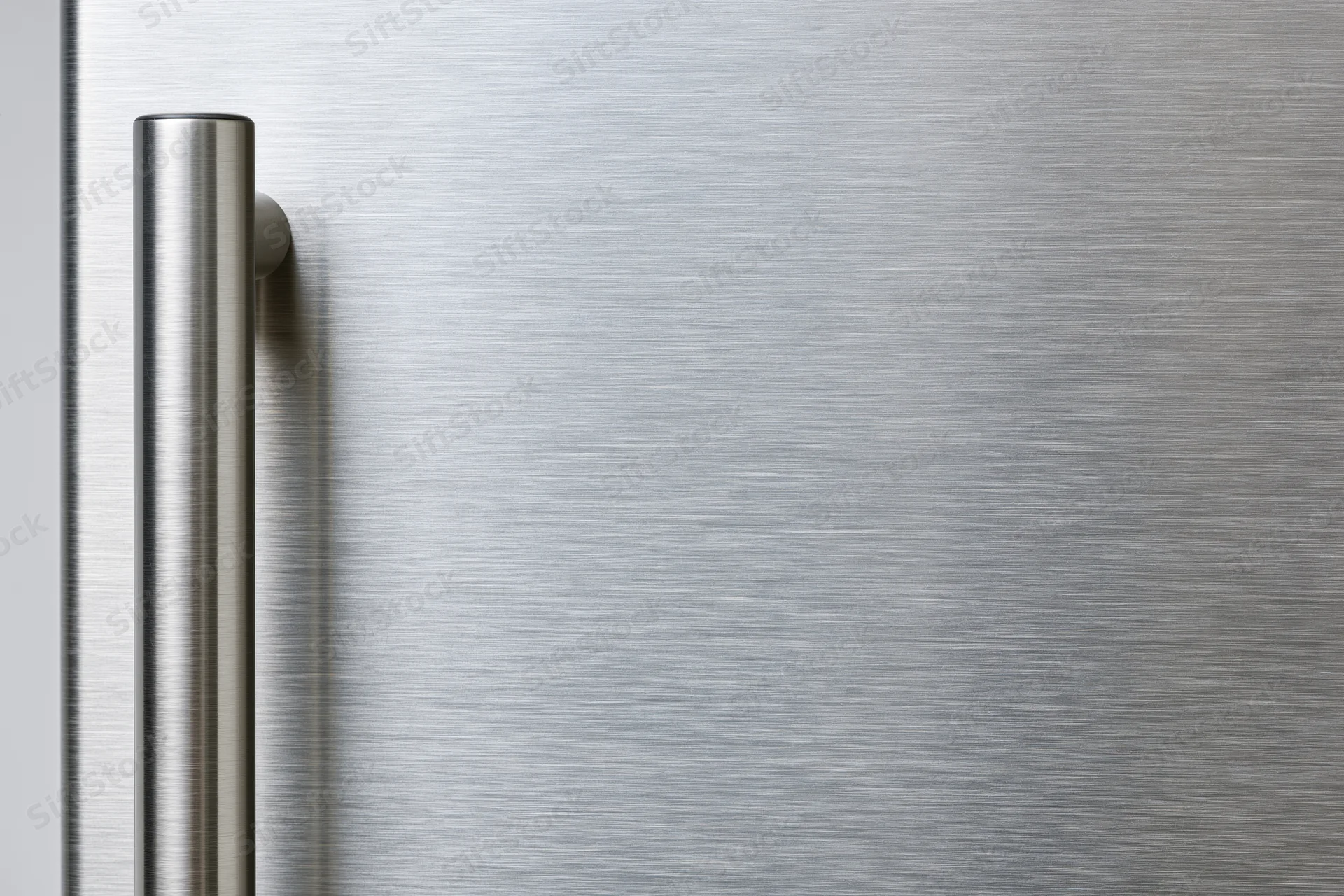 Close-up of a brushed stainless steel refrigerator door with vertical handle