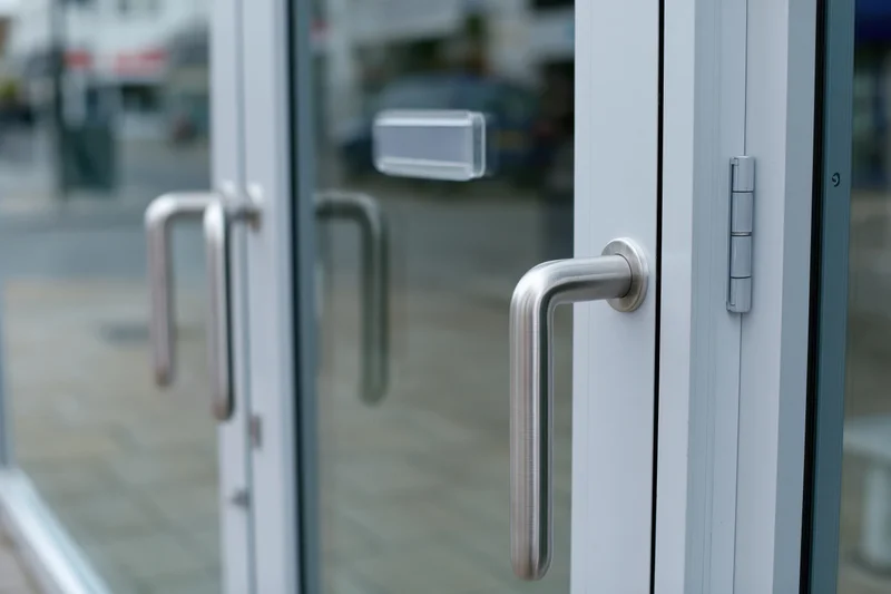 Close-up of a commercial glass door with brushed aluminum pull handle and metal frame