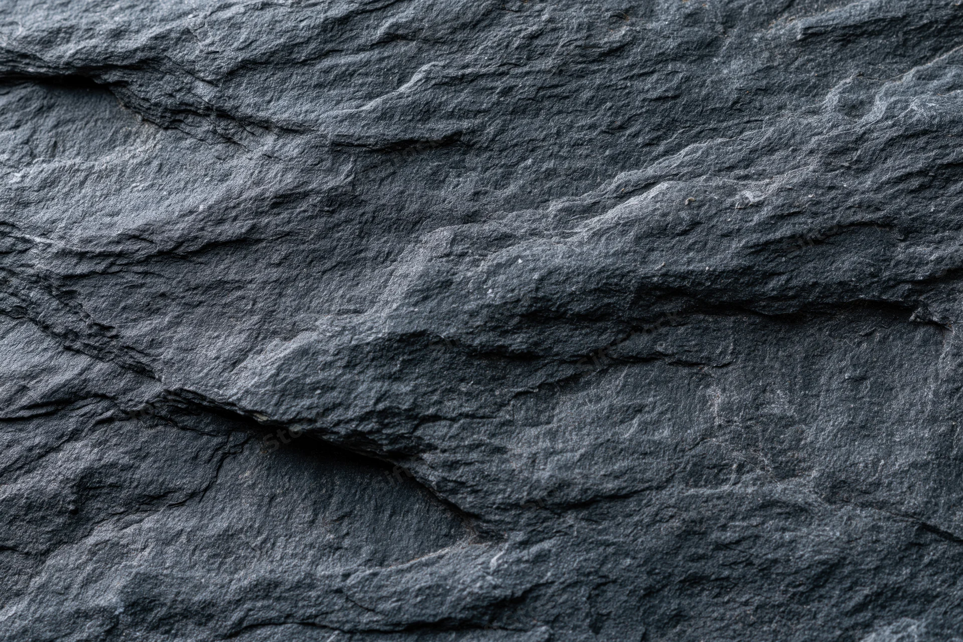 Dark slate rock surface with layered texture filling the frame
