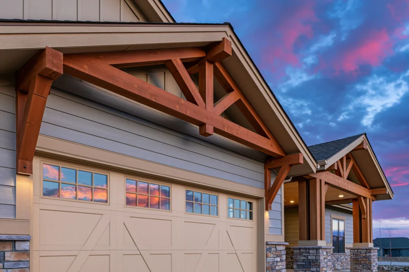 Craftsman-style home exterior featuring garage with wooden beams and covered entryway under twilight sky
