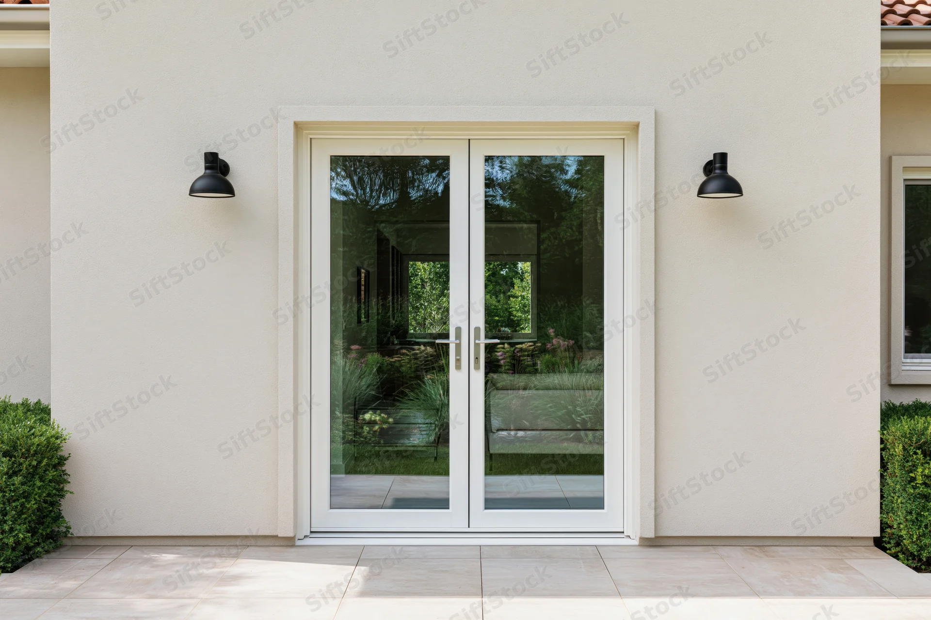 Modern suburban house facade with white double glass doors and black wall sconces flanking the entrance