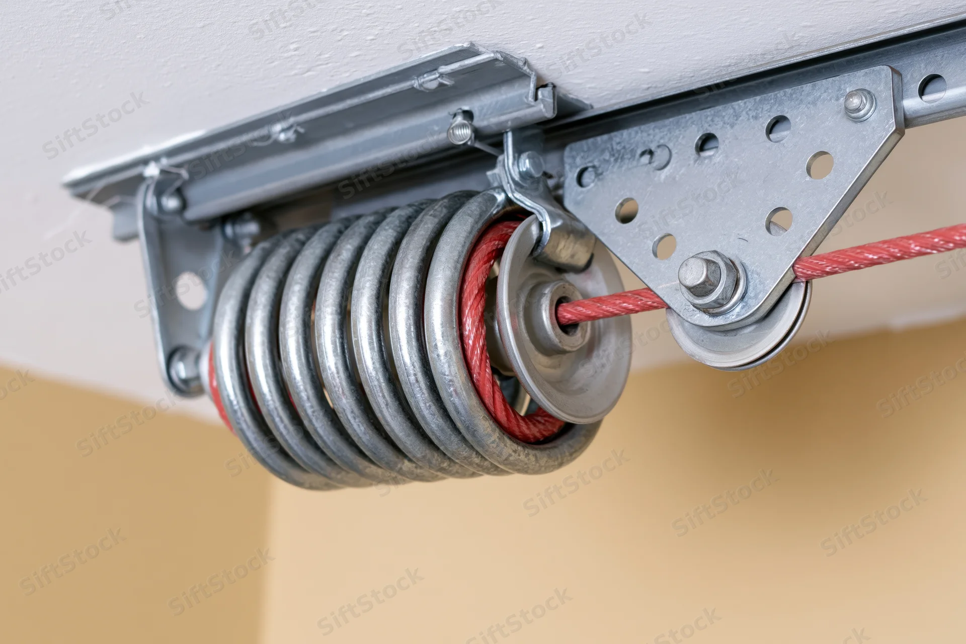 Garage door torsion spring and cable drum assembly mounted on ceiling bracket