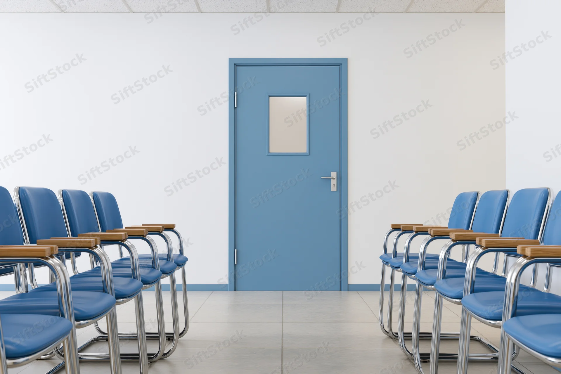Rows of blue chairs facing a pale blue door in a hospital waiting room corridor